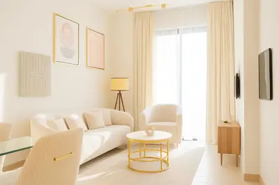 a white living room with a white couch and a table at Luxe 1BR 15mins-Beach Best Infinity Pool -Jumeirah Village Circle, JVC ,Dubai in Dubai