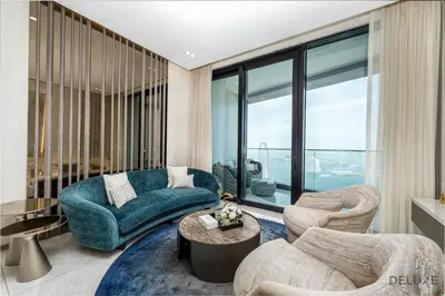 a living room with a blue couch and chairs at Ultra Luxurious 4BR with Assistant Room in The Address Residences, JBR by Deluxe Holiday Homes in Dubai