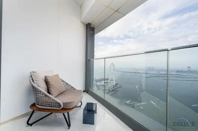 a chair on a balcony with a view of the water at Ultra Luxurious 4BR with Assistant Room in The Address Residences, JBR by Deluxe Holiday Homes in Dubai