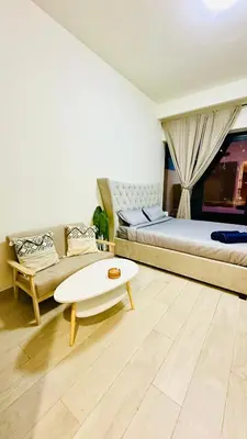 a bedroom with a bed and a couch and a table at Luxury Studio with big balcony Azizi Riviera Meydan in Dubai