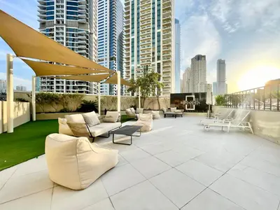 a rooftop patio with white furniture and a city skyline at SettlerHomes- Breathtaking 2BR Marina High-Floor in Dubai