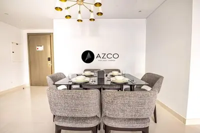 a dining room with a table and chairs at Panoramic 2BR - 3 Balconies & Canal Views - Damac Maison Prive by AZCO Holiday Homes in Dubai