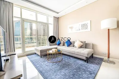a living room with a couch and a table at Panoramic 2BR - 3 Balconies & Canal Views - Damac Maison Prive by AZCO Holiday Homes in Dubai
