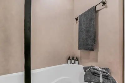 a bathroom with a bath tub and a towel at Luxueux Studio, Top emplacement in Dubai