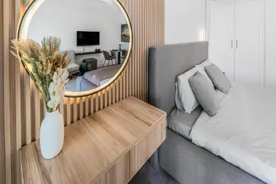 a bedroom with a bed and a mirror and a table at Luxueux Studio, Top emplacement in Dubai