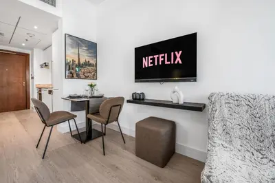 a living room with a tv on a wall at Luxueux Studio, Top emplacement in Dubai