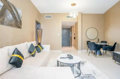 a living room with a white couch and a table at Specious pool view One Bed room in Dubai
