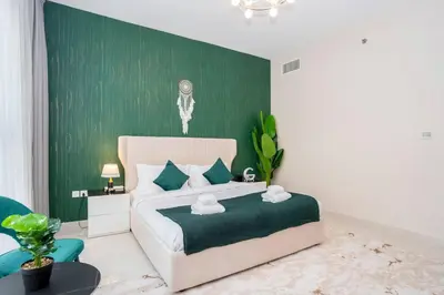 a bedroom with a bed with a green accent wall at Specious pool view One Bed room in Dubai