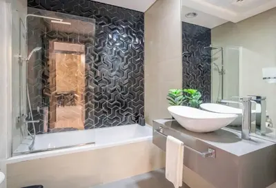 a bathroom with two sinks and a shower at Specious pool view One Bed room in Dubai