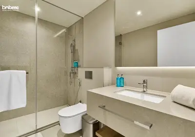 a bathroom with a toilet and a sink and a shower at bnbme - Luxury 1BR La Vie Apt Beach Access Pool Gym Balcony & Stunning Dubai Eye Views in Dubai