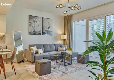 a living room with a couch and a table at bnbme - Luxury 1BR La Vie Apt Beach Access Pool Gym Balcony & Stunning Dubai Eye Views in Dubai