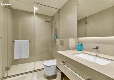 a bathroom with a toilet and a sink and a shower at bnbme - Luxury 1BR La Vie Apt Beach Access Pool Gym Balcony & Stunning Dubai Eye Views in Dubai