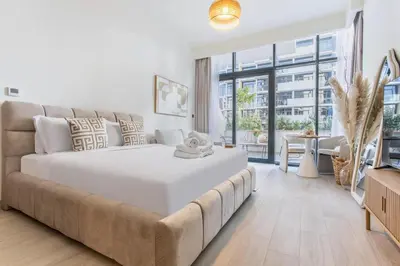 a bedroom with a large white bed and a couch at Artist Heaven Studio! Riviera 35! 10 min Downtown in Dubai