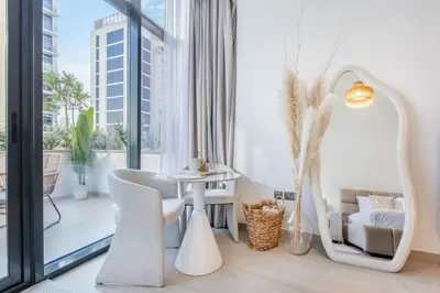 a living room with a table and chairs and a large window at Artist Heaven Studio! Riviera 35! 10 min Downtown in Dubai