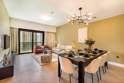 a living room with a dining room table and chairs at Daniels Luxe 3BR Downtown with Skyline View in Dubai