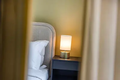 a lamp sitting on a table next to a bed at Daniels Luxe 3BR Downtown with Skyline View in Dubai