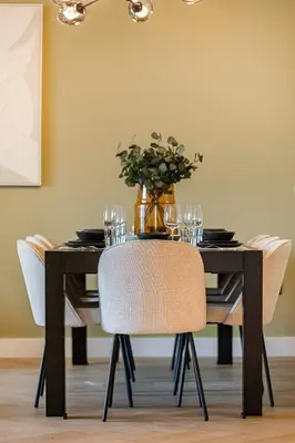 a black dining room table with chairs and a vase at Daniels Luxe 3BR Downtown with Skyline View in Dubai