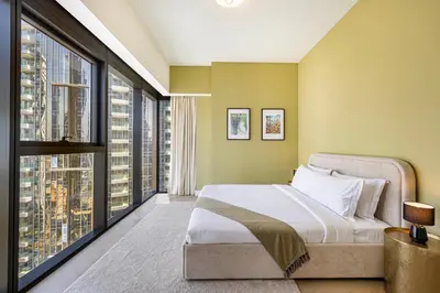 a bedroom with a large bed and large windows at Daniels Luxe 3BR Downtown with Skyline View in Dubai