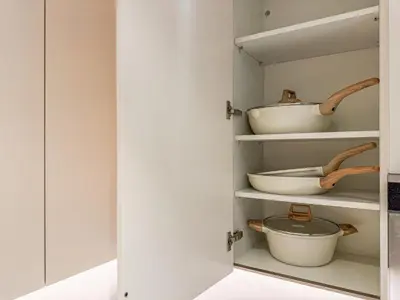 a cupboard with bowls and pans in it at SettlerHomes - Chic Jumeirah Gate with Beach Access in Dubai