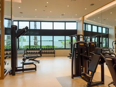 a gym with cardio equipment and large windows at SettlerHomes - Chic Jumeirah Gate with Beach Access in Dubai