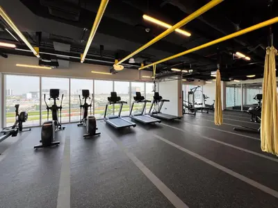 a gym with treadmills and ellipticals and windows at Frank Porter - Socio Tower 2 in Dubai