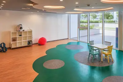 a room with a table and chairs on a green floor at Frank Porter - 1 Residences in Dubai