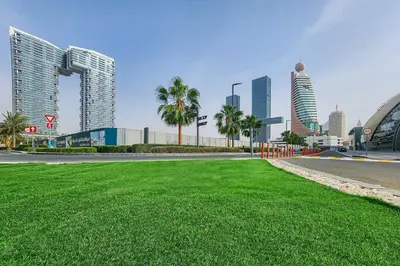 a city with tall buildings and a field of grass at Frank Porter - 1 Residences in Dubai