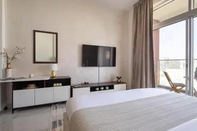 a bedroom with a bed and a tv on the wall at Frank Porter - Jwelz By Danube in Dubai