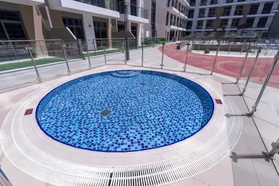 a large blue pool in the middle of a building at Brand New Building * Czechin * Studio City in Dubai