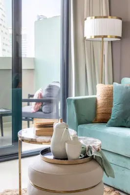 a living room with a blue couch and a table at Frank Porter - Zada Tower in Dubai