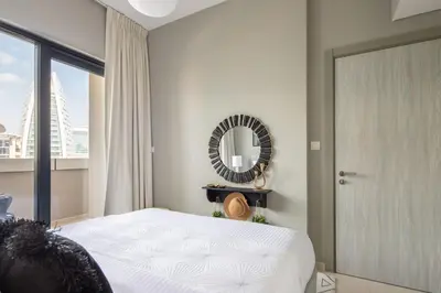 a bedroom with a bed and a mirror and a window at Frank Porter - Zada Tower in Dubai