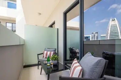 a balcony with two chairs and a table at Frank Porter - Zada Tower in Dubai