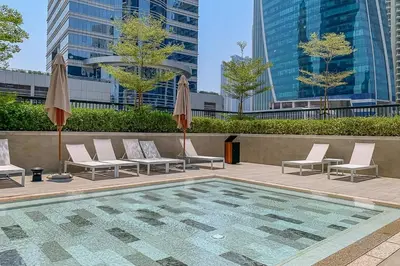 a pool with chairs and umbrellas in a city at Frank Porter - Zada Tower in Dubai