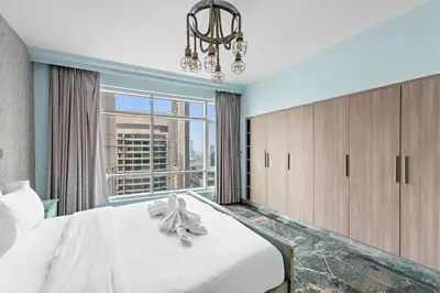 a bedroom with a large bed and a window at FIRST CLASS 2BR Stunning Fountain View in Dubai
