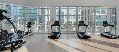 a gym with cardio machines and a large window at Panoramic LUX Apartment with Burj Khalifa View in Dubai