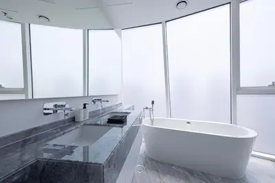 a bathroom with a large white tub and windows at Panoramic LUX Apartment with Burj Khalifa View in Dubai