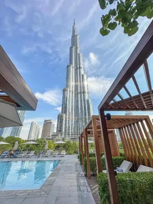 a large building with a pool in front of a city at Luxury 1BR The Address Opera, Downtown Dubai in Dubai