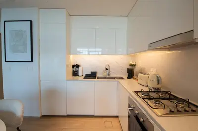 a white kitchen with a sink and a stove at The Palace 405 I Luxury 2BD I Dubai Creek Harbour in Dubai
