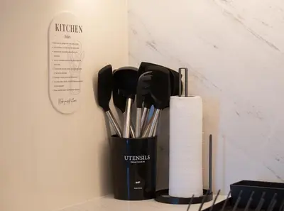a cup filled with utensils next to a paper towel at The Palace 405 I Luxury 2BD I Dubai Creek Harbour in Dubai