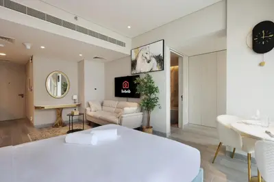 a bedroom with a white bed and a living room at Livbnb - Sea and Marina View, Steps to Marina Walk in Dubai
