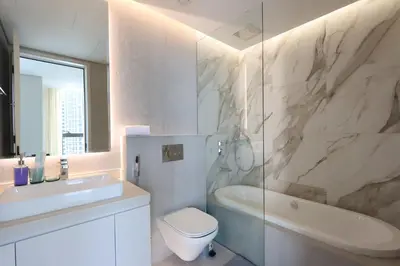 a bathroom with a toilet and a tub and a sink at Livbnb - Sea and Marina View, Steps to Marina Walk in Dubai