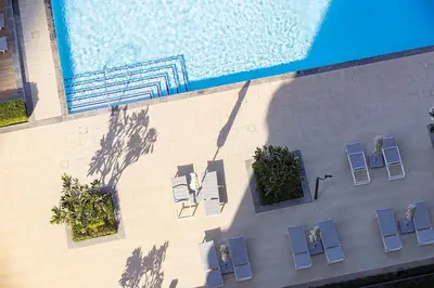 an overhead view of a swimming pool with chairs and a swimming pool at Burj Crown - New Sky High, Near Burj Khalifa, Boulevard View, Opposite Dubai Mall in Dubai