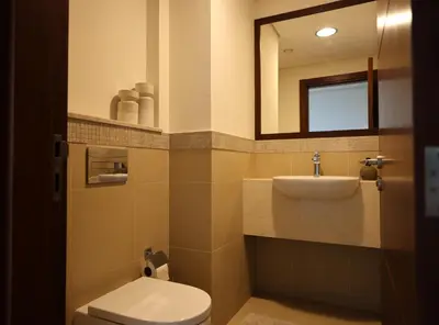 a bathroom with a toilet and a sink and a mirror at Elegant 1BR Oasis Burj Vista Steps to Burj Khalifa - 11AB08 in Dubai