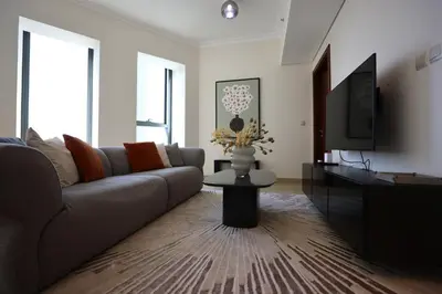 a living room with a couch and a tv at Elegant 1BR Oasis Burj Vista Steps to Burj Khalifa - 11AB08 in Dubai