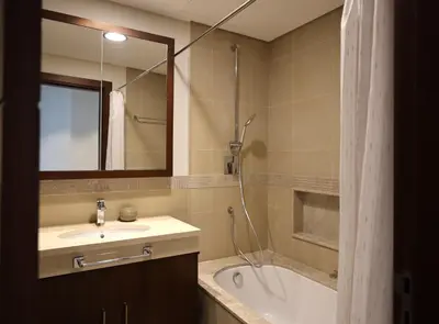 a bathroom with a sink and a tub and a mirror at Elegant 1BR Oasis Burj Vista Steps to Burj Khalifa - 11AB08 in Dubai