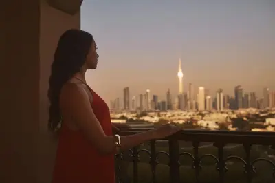 a woman standing on a balcony looking at the city at Four Seasons Resort Dubai at Jumeirah Beach in Dubai