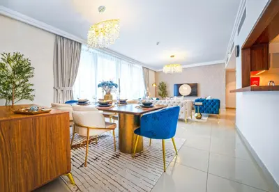 a kitchen and living room with a table and chairs at EasyGo - Upgraded 2BDR in BLVD Point with Burj Khalifa View in Dubai