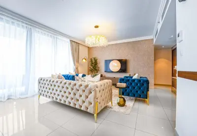 a living room with a couch and a table at EasyGo - Upgraded 2BDR in BLVD Point with Burj Khalifa View in Dubai