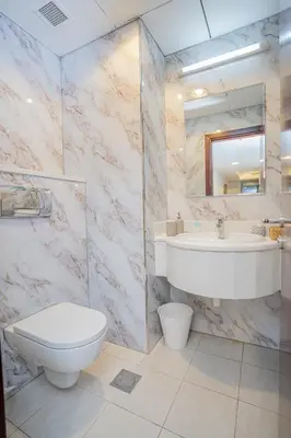 a bathroom with a toilet and a sink and a mirror at VIBES by Beds and Company - 51st Floor, Full Sea View in Dubai