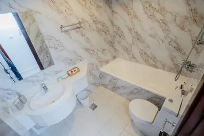 a bathroom with a sink and a toilet and a mirror at VIBES by Beds and Company - 51st Floor, Full Sea View in Dubai